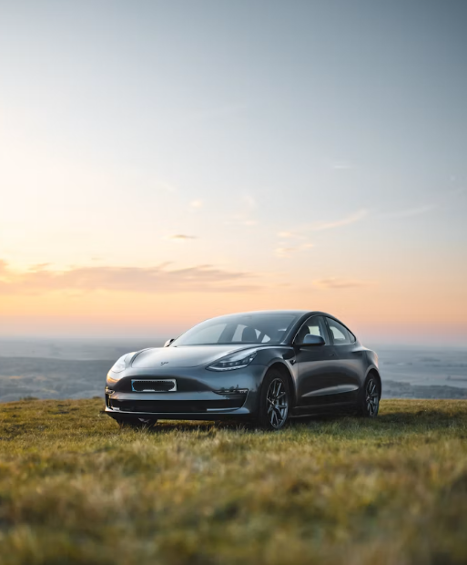 Tesla rijdt door bergwegen in de Eifel bij zonsondergang met uitzicht op vulkanisch landschap